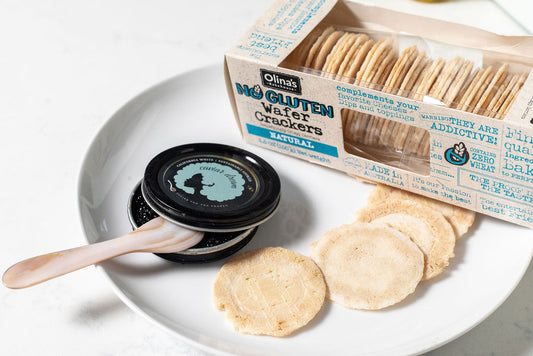 Olina's gluten-free wafer crackers on a plate with a container of California White caviar.