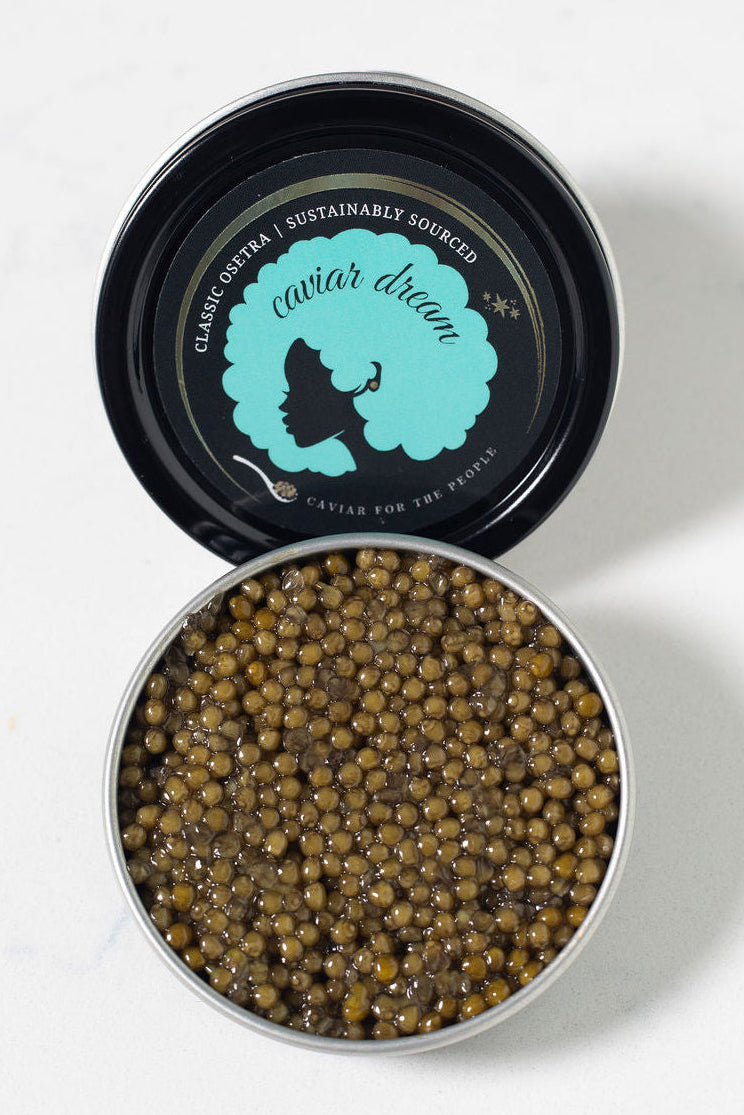 Open tin of caviar with visible Caviar Dream brand logo on a white background