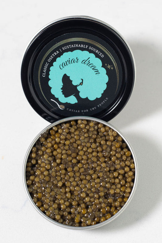 Open tin of caviar with visible Caviar Dream brand logo on a white background
