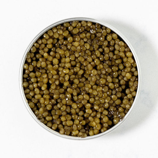 Close-up of Imperial Osetra -- golden-olive green caviar on a white background