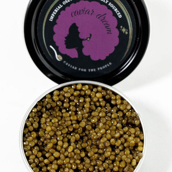 Open tin of Imperial Osetra caviar with a branded lid on a white background.