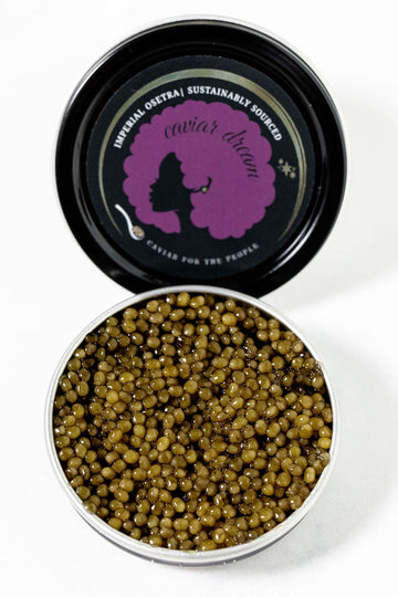 Open tin of Imperial Osetra caviar with a branded lid on a white background.