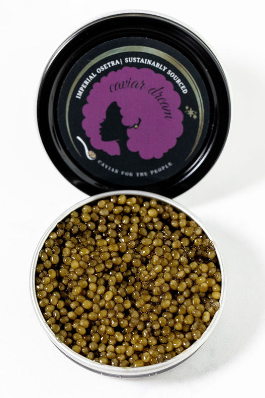 Open tin of Imperial Osetra caviar with a branded lid on a white background.