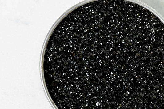 Close-up of black Hackleback caviar in a metal container on a white background